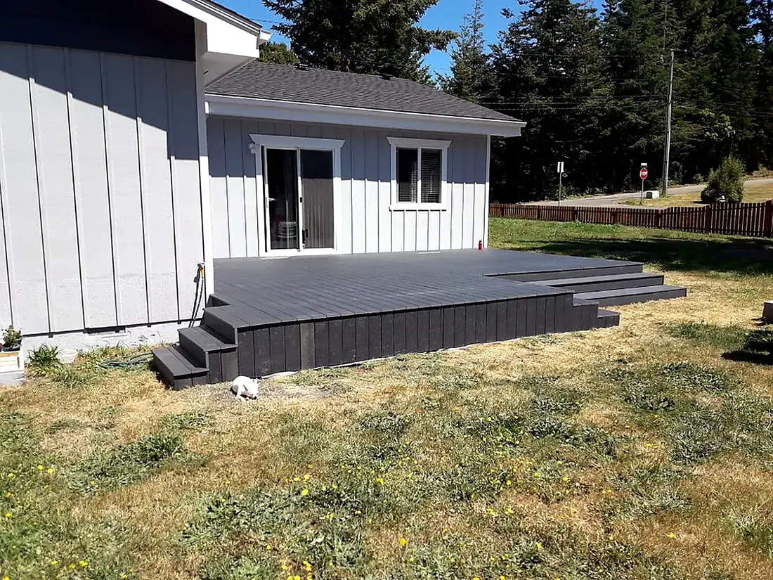 Wide finished composite deck wrapping a coastal home, built by SeaBreeze